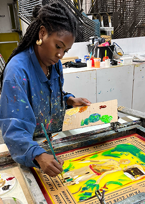 Davinia Clarke monoprinting onto a silk screen during her artist residency at Print Club London