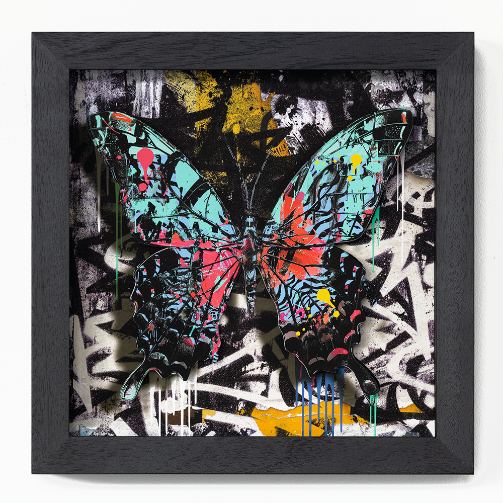 **The Urban Butterfly No.1 - SMALL FRAMED (Copy)**  In "The Urban Butterfly No. 1," the artist masterfully merges the raw, unrestrained energy of graffiti with the delicate beauty of nature. Enclosed within a sleek black frame, this captivating piece draws the viewer into its vibrant world where bold splashes of turquoise, red, yellow, and pink dance harmoniously on a black and white abstract backdrop. The butterfly, adorned with these vivid hues, becomes the focal point in an interplay between chaos and serenity. Expertly dripped paint intersperses throughout the composition, enhancing its dynamic movement and highlighting areas that captivate and mesmerize. This artwork not only celebrates street art's audacious spirit but also attests to the artist's exceptional craftsmanship in balancing modern vibrancy with timeless elegance.