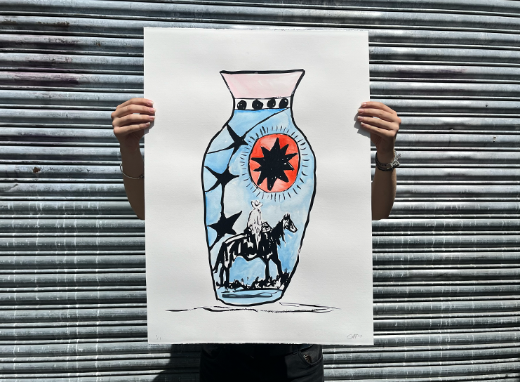 A person holds a large Print Club London drawing of a decorative vase with a star design and a silhouette of a horse and rider, set against a corrugated metal background.