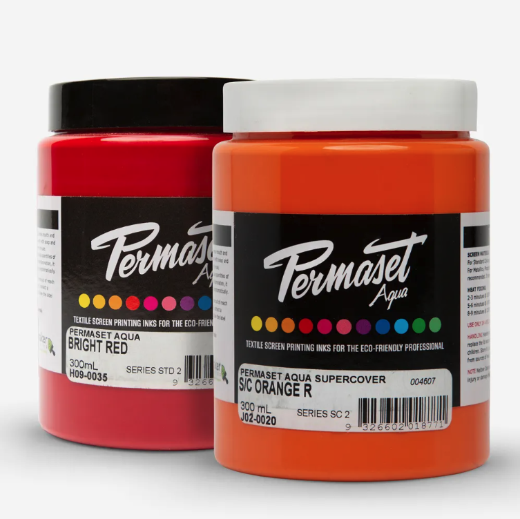Two jars of Permaset Aqua Screenprinting Fabric Standard ink—one bright red, one orange—ideal for art projects, with visible labels and color indicators.