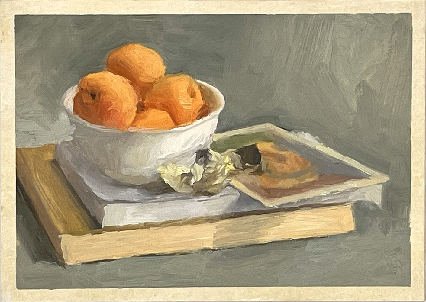 A white bowl of oranges sits on stacked books next to a small pastry and a piece of crumpled paper, all set against a muted background.