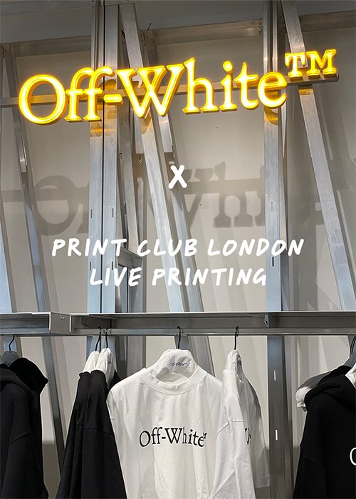 Clothing display with Off-White™ logo in yellow neon above, and text reading "Print Club London Live Printing" on the wall; various Off-White™ shirts are hanging below—a striking setup often featured at Live-Events-and-Corporate-Workshops.